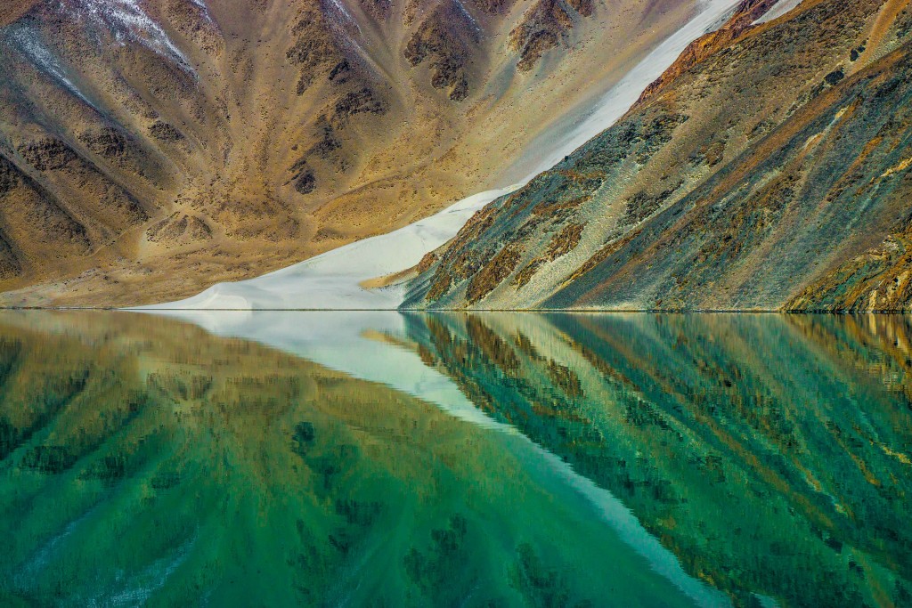 Nahaufnahme wie sich Berg und Schneefeld im See spiegeln