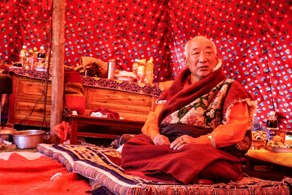 Und hier nun der höchste in der Riege. Manche haben mir erklärt er sei ein "living Buddha". Ich bin mir nicht sicher ob ich das alles richtig verstanden habe, aber er war auf jeden Fall der ranghöchste aller Figuren. Die Beiwohnung der Zeremonie war für ihne ausser Frage, er hielt in seinem eigenen Zelt am Rande, abgeschirmt von seinen Mömchen, Hof und empfing nur nach seinem oder dem seiner Berater, Gutdünken. Da wir die einzigen Ausländer waren und es ihn im Magen gezwickt hat, hatten wir die Ehre eine Audienz zu erhalten. Ehrlich gesagt kam ich mir dabei schlecht vor, v.a. da ich beobachtet habe wie recht viele einfache einheimische Leute abgewiesen wurden. Es war für mich ein eindrückliches Erlebnis, aber auch mit vielen gemischten Gefühlen und ein Schlüsselerlebnis den tibetischen Buddhismus aus einer etwas mehr kritischen Warte zu betrachten, genauso wie ich das mit all den anderen Glauben mache.